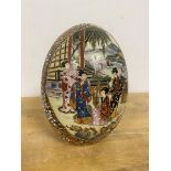 A Satsuma egg shaped table ornament with two panels depicting women on veranda playing instruments