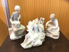 A group of three Nao figures including girl on suitcase with duck in basket measures 27cm high, girl