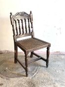 A 19th century Anglo-Indian chair, possibly padouk, with scrolled crest rail over turned spindle