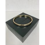 A 9ct gold bangle with clasp and Greek key engraving to exterior measures 6x5.5 cm and weighs 5.93