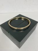 A 9ct gold bangle with clasp and Greek key engraving to exterior measures 6x5.5 cm and weighs 5.93