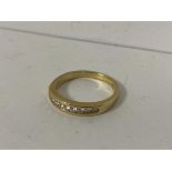 An 18ct gold ring channel set with nine diamonds size Q weighs 4.06grammes