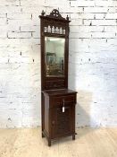 An Edwardian style mahogany hall stand, the mirror back with two coat hooks above a drawer and