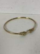 A 14ct gold bangle with ends terminating in ram's heads measures 6.5x5cm and weighs 8.05grammes