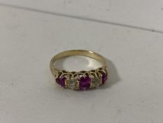 A yellow metal ring with three old cut rubies separated by diamonds size Q/R