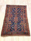 An antique hand-knotted rug, probably Kurdistan, the deep blue field of geometric design, framed