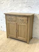 A modern oak sideboard, fitted with two drawers above twin cupboard doors, raised on stile supports,