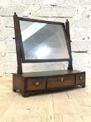 A Regency mahogany toilet mirror, with brass acorn finials over reeded uprights, the bow front