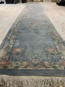A large Chinese washed wool runner rug, the blue field with three medallions enclosed by a floral