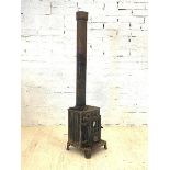 A cast iron log burning stove and flue, H177cm, W39cm, D44cm