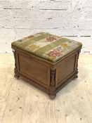 A Victorian walnut lidded stool, the floral needlework and velvet upholstered top lifting to