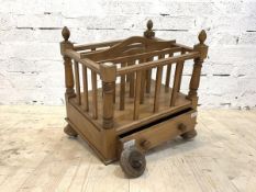 A walnut and beech three division Canterbury with drawer, raised on turned supports with castors, (