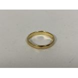 An 18ct gold wedding band size M and weighs 2.61 grammes