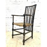 An early 20th century oak armchair, the rail back over string seat and spiral turned front supports,