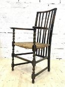 An early 20th century oak armchair, the rail back over string seat and spiral turned front supports,