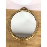 An oval wall mirror with gilt composition frame, some losses, measures 41cm x 35cm