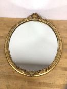 An oval wall mirror with gilt composition frame, some losses, measures 41cm x 35cm