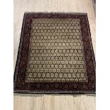 A hand knotted rug from the North West Persian region, the field with repeating design framed in a