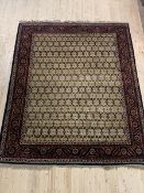 A hand knotted rug from the North West Persian region, the field with repeating design framed in a