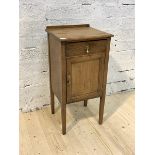 An early 20th century oak bedside table, with single drawer and cupboard, raised on square section