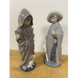 Two Nao figures each of a young child in raincoat with animals measure 27cm high (2)