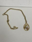A 10ct gold pendant of fruit and leaf design on a chain marked 1/20 12K, measures 22cm with a