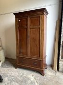 An Edwardian inlaid mahogany wardrobe, the dentil cornice over twin panelled doors with egg and dart