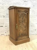 A Late Victorian figured walnut bedside cupboard, the raised back over panelled door enclosing a