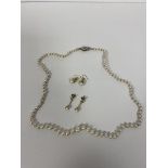 A single strand of graduated cultured pearls with silver clasp measures 23cm along with two pairs of