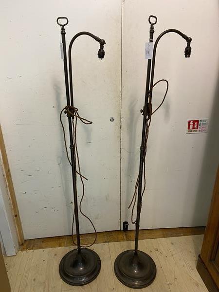 A pair of Edwardian adjustable polished metal reading floor lamps on a dishes base, measure 150cm