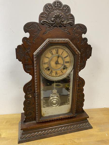 A 1920's mantel clock with moulded frame measures 58cm high