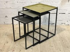 A nest of three powder coated aluminium tables, each with enameled tray tops, H52cm, 41cm x 41cm
