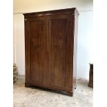 An Edwardian mahogany wardrobe, the twin panelled doors enclosing interior fitted for hanging and