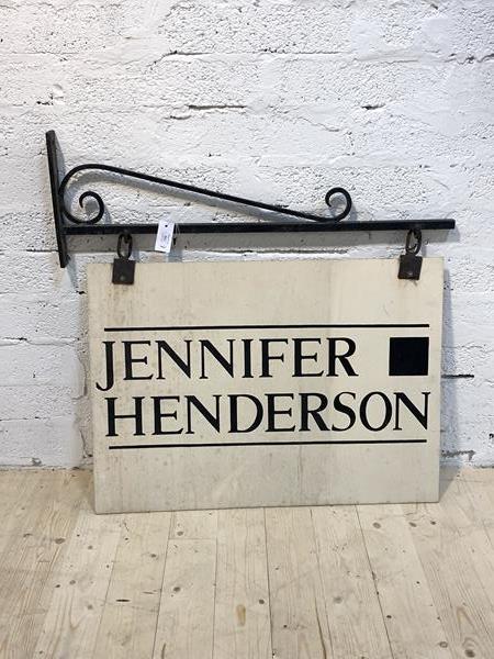 A Scrolled wrought iron shop sign bracket, with sign reading Jennifer Henderson bracket measures