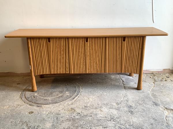 Ercol, a blonde sideboard, the rectangular top over base centred with a pull out drawer having a