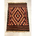 A tribal Kilim rug, the abrashed brown field with all over geometric design, 118cm x 80cm