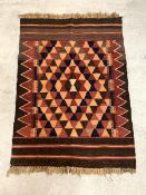 A tribal Kilim rug, the abrashed brown field with all over geometric design, 118cm x 80cm