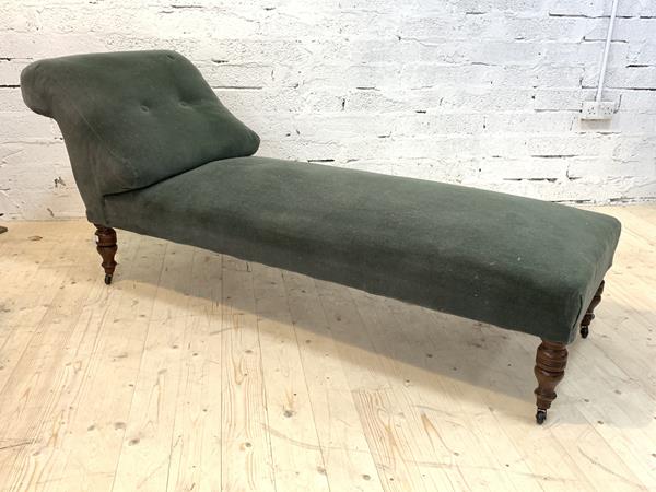 A Victorian chaise longue, upholstered in green velvet, raised on turned supports with later