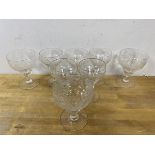 A set of seven wine glasses with vine and fruit etched decoration and knop to stem, measures 14cm
