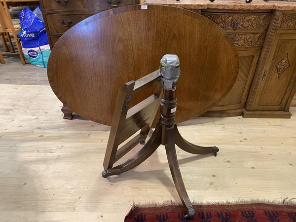 Reprodux, A Regency style mahogany loo table, the oval cross banded top raised on a turned column