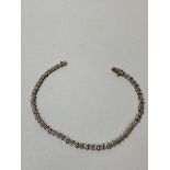 A 9ct gold tennis style bracelet with diamonds measures 20cm, weighs 4.40 grammes