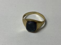 A 9ct gold signet style ring with worn polished stone plaque, size V, weighs 3.24 grammes