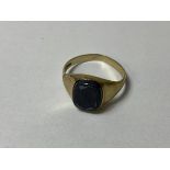 A 9ct gold signet style ring with worn polished stone plaque, size V, weighs 3.24 grammes