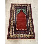 A Hand-knotted prayer rug, with central Mihrab and multi-line border, 175cm x 103cm