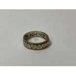 A full eternity style ring with a repeating heart shaped frieze, each with a clear stone to