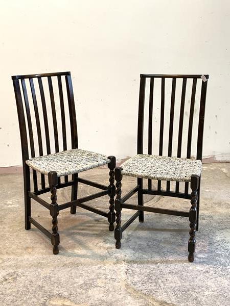 A pair of beech framed side chairs, with rail backs, string seats, raised on spiral turned front