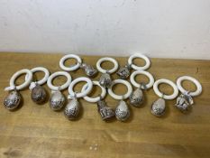A collection of twelve silver plated teething rings with eight egg shaped and ribbon decorated