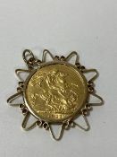 A George V 1911 gold sovereign in 9ct gold mount, combined weight 10.14grammes