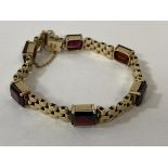 A 9ct gold red stone set bracelet measures approximately 6cm diameter combined weight of 19.85