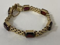 A 9ct gold red stone set bracelet measures approximately 6cm diameter combined weight of 19.85